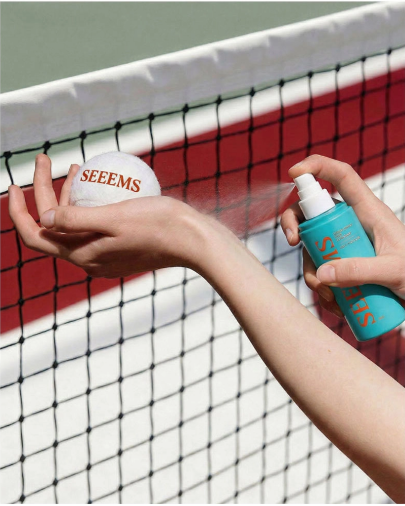 A woman spraying Seem's Performance Body Refresher