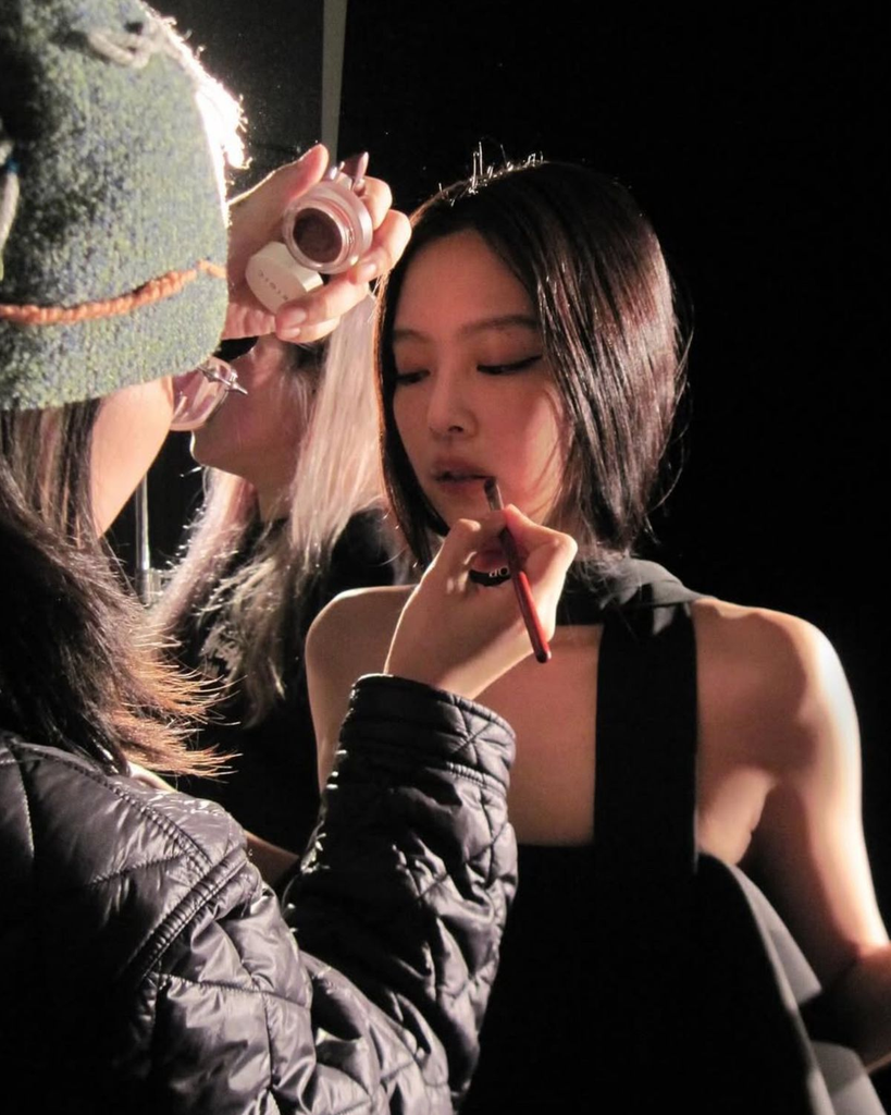 Kpop artist, Jennie, getting her makeup touched up for a photoshoot
